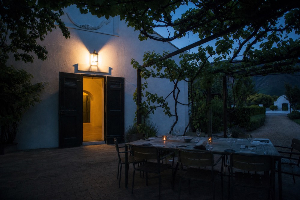 Outdoor dining table set under vines at a Franschhoek winery, no text, no logos, no people