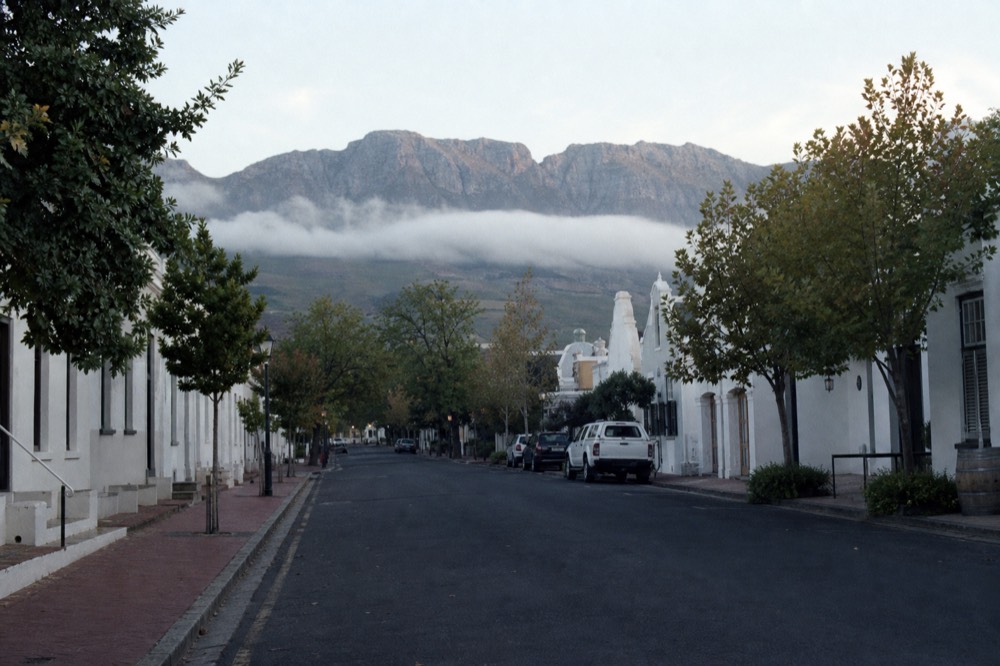Stellenbosch town center with historic buildings and mountain backdrop, no text, no logos, no people