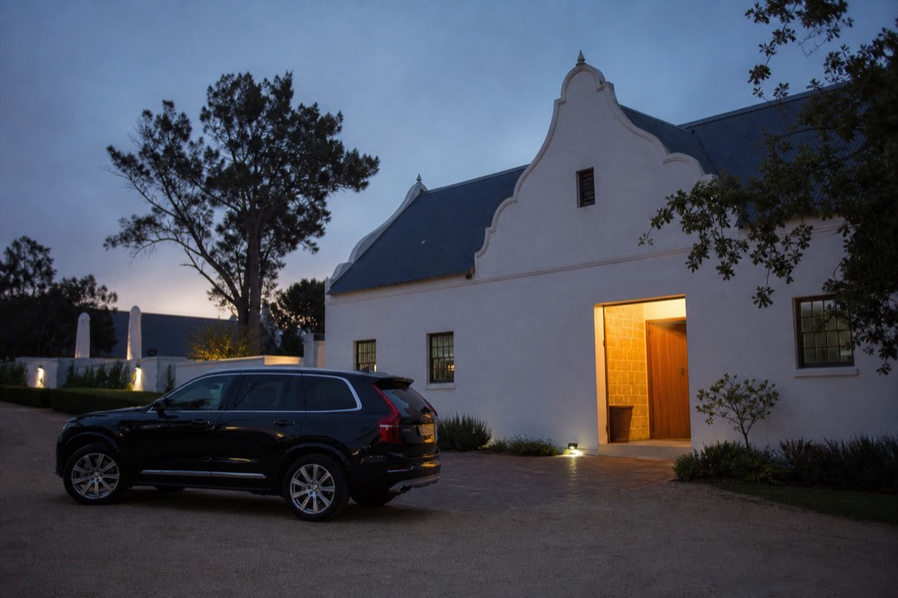 A luxury wine tour vehicle parked in front of a vineyard estate, no text, no logos, no people